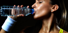 woman hydrating after workout session